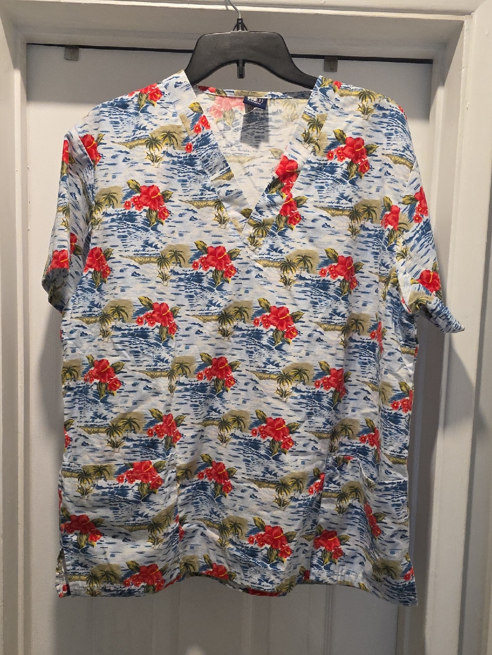 Light Blue Tropical Print Scrub. Short Sleeve Shirt with Red Floral Accents
